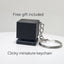 Black clicky miniature keychain on a white surface with text indicating a free gift offer.